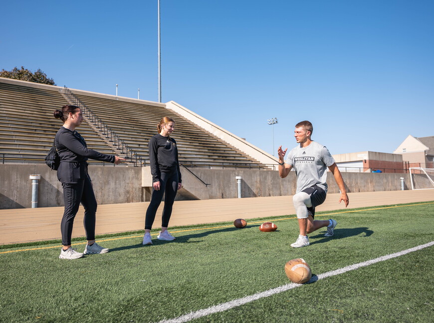 Student athletic trainers work with a student athlete. 