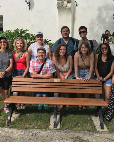 Students gather around a bench