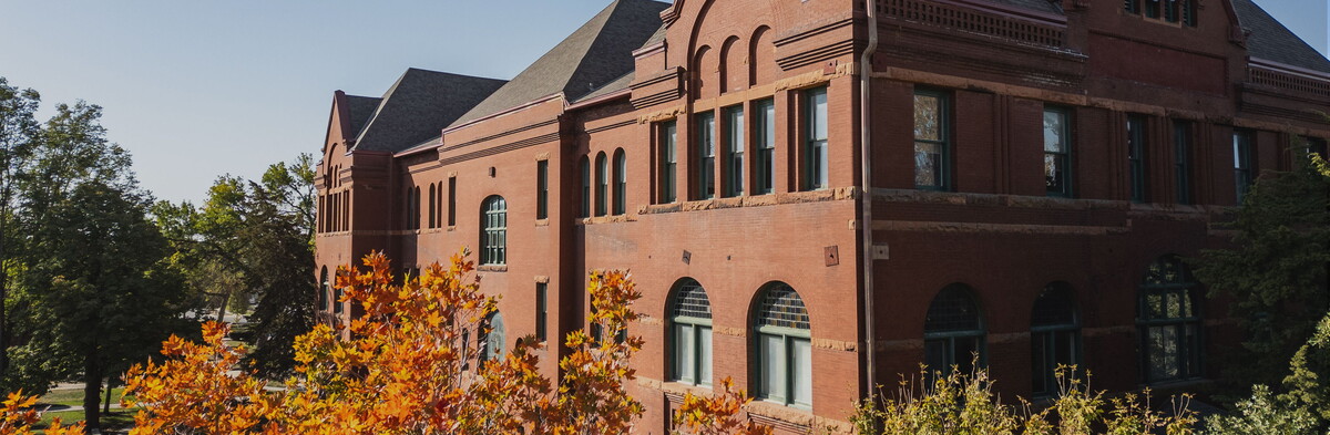 Trees in fall colors surround the top of the Old Main building.