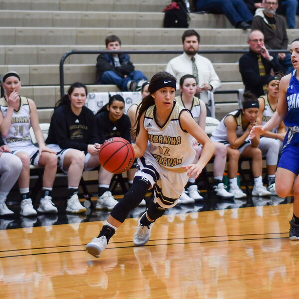 Caitlin Navratil dribbling during a home basketball game.