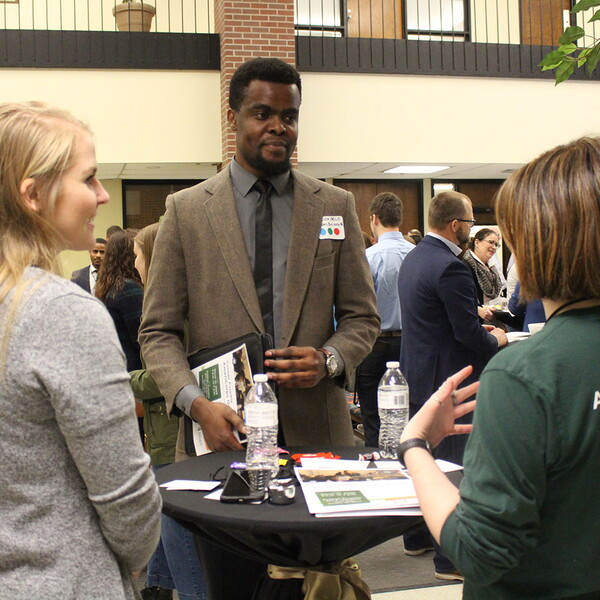 Male student talks to visiting business professionals at the Backpack-to-Briefcase professional networking event.