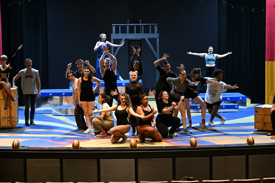 Many student actors rehearsing on a stage.