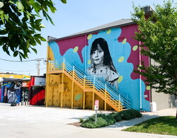 The back of The Lux Center for the Arts building with murals painted on it.