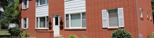 Tightly cropped view of the red-brick and white trimmed student apartment building.